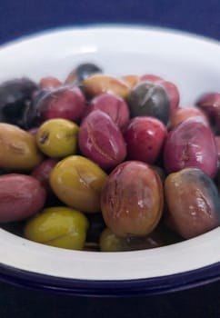 Ceramic bowl filled with cut pickled olives. Traditional method with the purpose of naturally eliminating the bitterness
