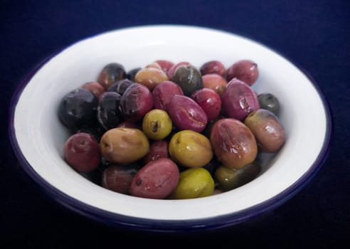 Ceramic bowl filled with cut pickled olives. Traditional method with the purpose of naturally eliminating the bitterness