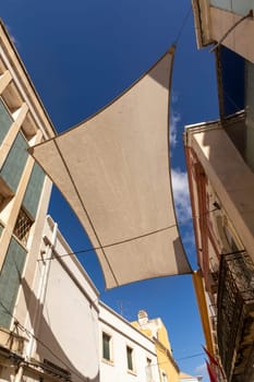 facade of old buildings in the old town of Faro, Portugal, Algarve in panoramic view with sun shadow