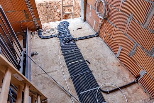 installation of electricity cable in cable canals at the floor of a construction site