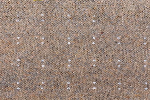 old brick pattern of old market square with markers for car parking gives a harmonic background