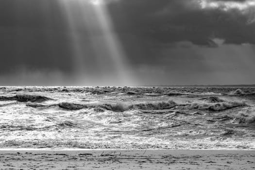 sea landscape with huge waves and a lightbeam in Sylt, Germany