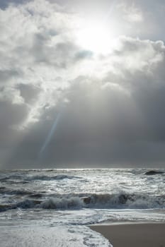 sea landscape with huge waves and a lightbeam in Sylt, Germany