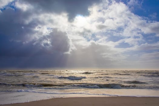 sea landscape with huge waves and a lightbeam in Sylt, Germany