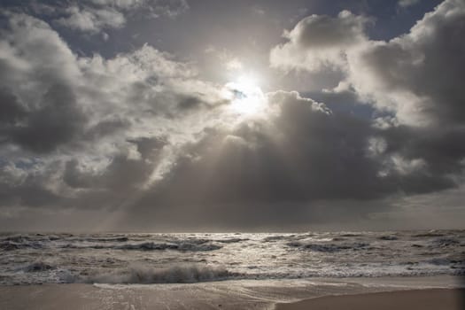 sea landscape with huge waves and a lightbeam in Sylt, Germany