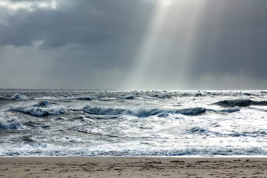 sea landscape with huge waves and sunbeam at the island of Sylt, Germany