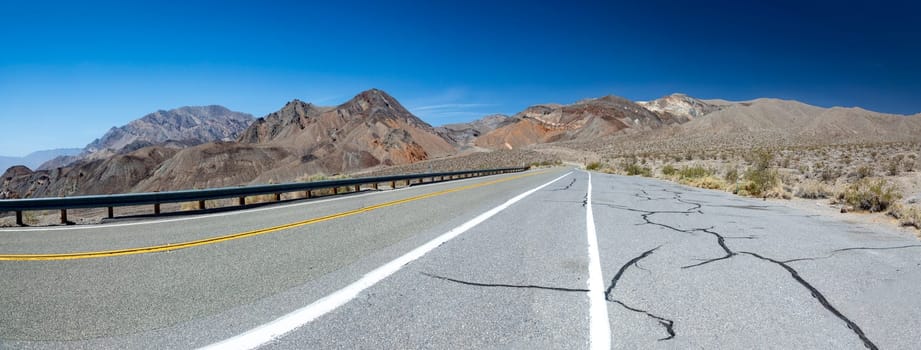 empty straight road thru the death valley with yellow median, USA