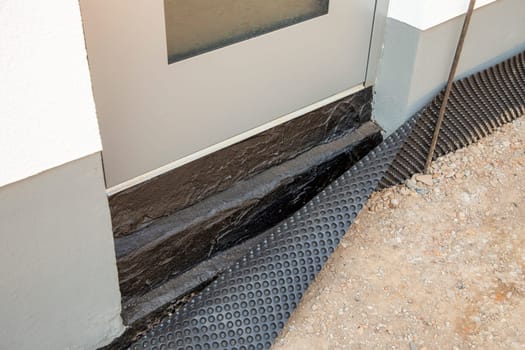 insulation with bitumen at an entrance door at the construction site