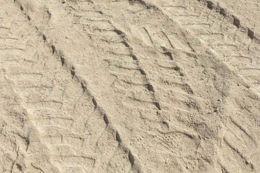 marks of a huge digger in the sand of the construction site