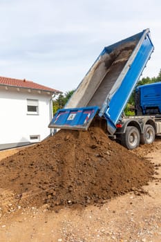 unloading the truck with potting soil from the truck bed at the construction site in Germany