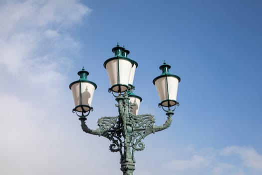 detail of old historic lantern under blue sky