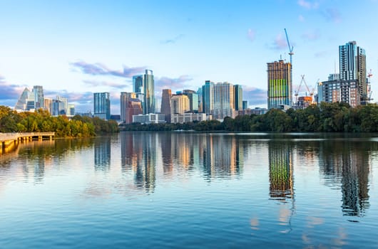 skyline of Austin in early morning light with mirroring city in the colorado river, Texas, USA