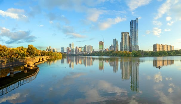 skyline of Austin in early morning light with mirroring city in the colorado river, Texas, USA