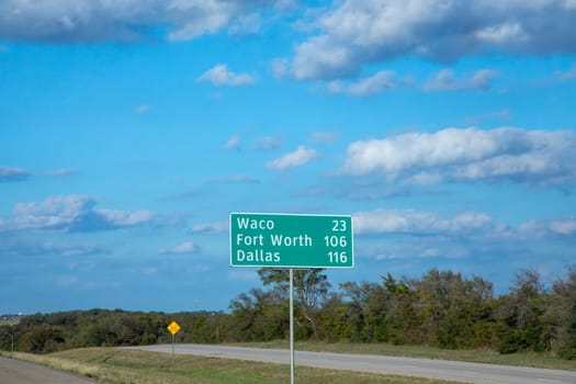 city distances to Waco, Fort Worth and Dallas at sign at interstate 35 without traffic on the street