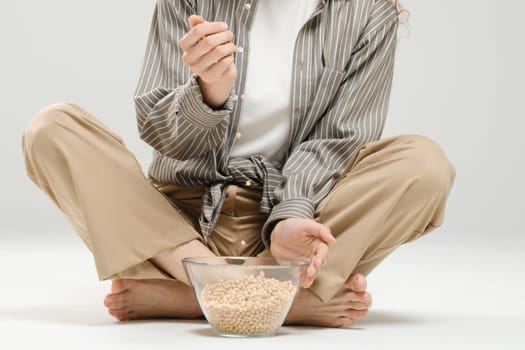 Unrecognizable woman pouring chickpeas into a bowl