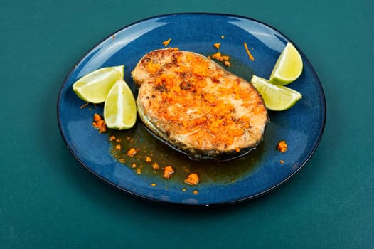 Roasted salmon or trout steak with orange and lime sauce. Top view.