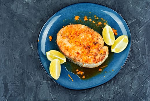 Roasted salmon or trout steak with orange and lime sauce. Top view.