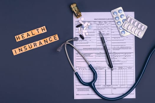 Health insurance form claim with stethoscope and pills on table. Medical insurance, health risk, pay for the healthcare concept.