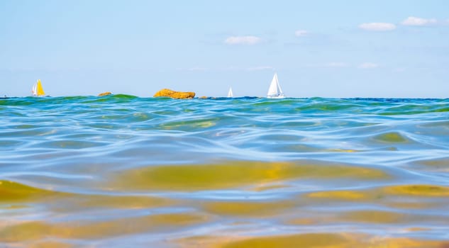 Sailing boats and waves seen by a swimmer at sea level, photography taken in Vendée, France
