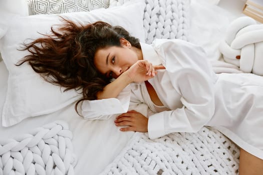 Sensual seductive young woman wearing sensual lingerie lying in bed. Female charm, purity and innocence concept