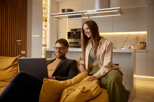 Happy family couple having nice conversation with friends or relatives using online video call chat on laptop computer and modern wireless technology