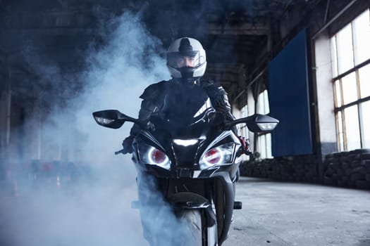 Motorcyclist riding fast at training motordrome of driving school. High speed extreme driving class