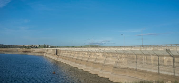 Float tube fisher close to Barragem do Caia wall, Campo Maior, Alentejo, Portugal. Long format