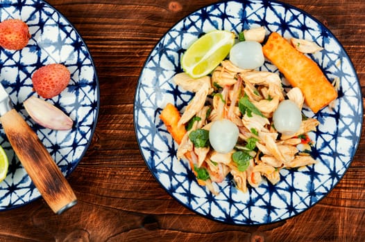 Plate of spicy Asian salad with lychee or litchi and chicken breast. Asian food. Top view.