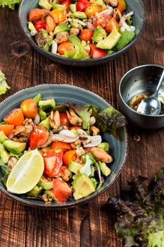 Tasty salad with mix of vegetables, seafood and fresh green lettuce in a bowl.