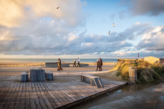 Calais, France - january 02 2023 : The port of Calais in winter, promenade of tourists flown over by seagulls. Photography taken in France