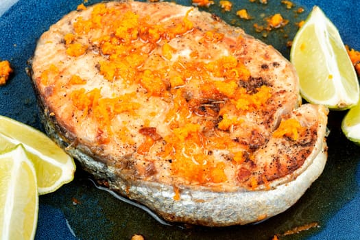 Grilled baked roasted salmon steak with orange and lime sauce. Roasted fish. Close up.