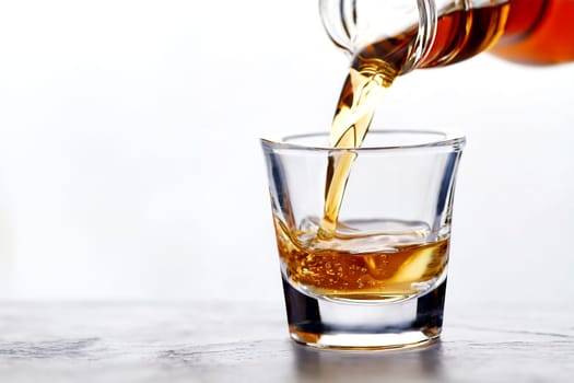 Whiskey being poured into a glass from a bottle on a white background. AI generated