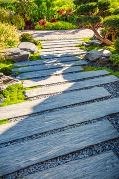 Zen stone path in a Japanese Garden with gravel and bark mulch and native plants