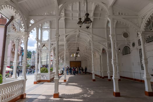 Karlovy Vary, Czech Republic - August 8, 2023. Carved wooden Market Colonnade,(Trzni kolonada), with mineral springs in historical centre. Pillared arcade, richly decorated interior in Swiss style. Tourist place.
