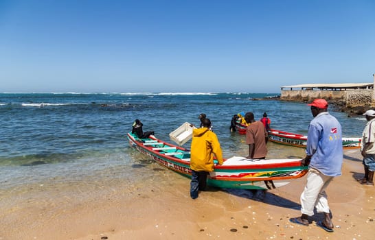 Dakar, Senegal. August 18, 2019: Fishermen with a fishing boat in a beach at Dakar, one of the many fishing beaches of Dakar, Senegal, West Africa