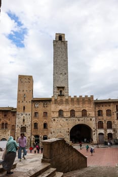 San Gimignano, Italy - Sept 17, 2022: Palazzo Vecchio del Podesta and the Rognosa Tower, also known as the Clock Tower or Podesta Tower in Piazza del Duomo in San Gimignano.
