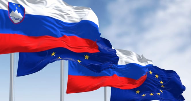 The flags of Slovenia and the European Union fluttering together on a clear day. Slovenia has been a member of the eurozone since January 1, 2007. 3D illustration render. Fluttering fabric