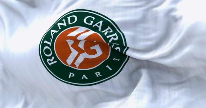 Paris, FR, Apr. 2023: White flag with Roland Garros logo waving in the wind. French Open is a major tennis tournament scheduled in late May each year. Illustrative editorial 3d illustration render