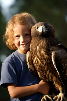 A young boy confidently holds a majestic bird of prey in his gloved hand outdoors.