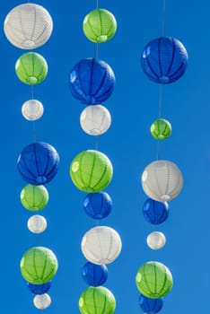 Party with colourful lampions hanging under a blue sky