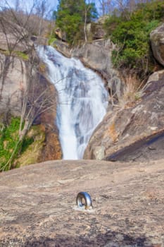 Bolt fixed over drilled rock for canyoning practice. Nogaleas waterfall as background