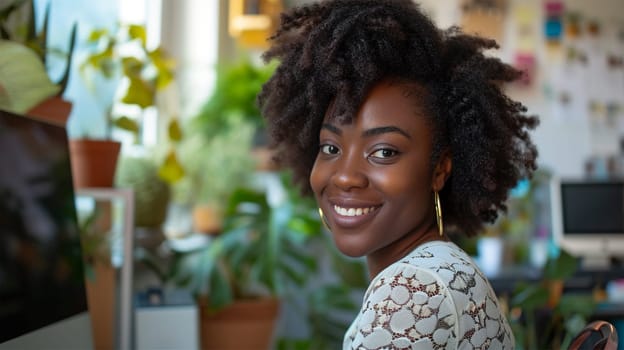 black woman in a white dress sitting at the computer, smiling and looking at the camera, lifestyle