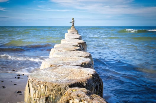 Groynes jut out into the Baltic Sea. Wooden trunks to protect the coast. Landscape from the sea