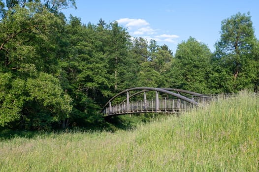 A pedestrian bridge over the Eder river in Germany, with green nature