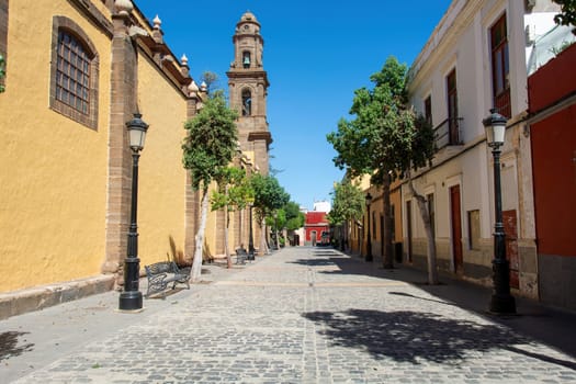 A street with houses in the old town of Galdar, with a view of the old church of Santiago de los Caballeros, on the Canary Island of Gran Canaria in Spain,A street with houses in the old town of Galdar, with a view of the old church of Santiago de los Caballeros, on the Canary Island of Gran Canaria in Spain