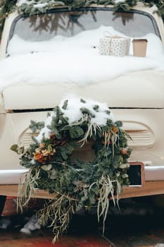 Vintage car decorated for the holidays Christmas, car front decorated with wreath.