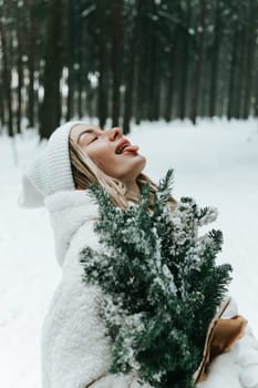 Happy young woman catching snowflakes with mouth in winter forest
