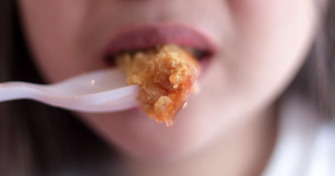 Woman eating fried chicken blurred background, Street food in thailand