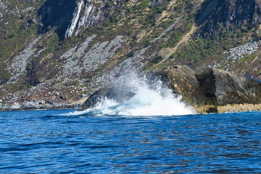 norway on the fjord, spray on rocks. Water splashes on the stones. Coastal landscape in Scandinavia. Landscape photo from the north