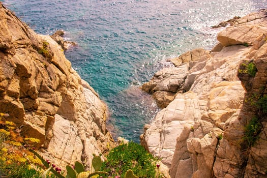 Rocky landscape. Beautiful rocky cliffs with cacti on the Costa Brava in Spain near the beach of Lloret de Mar on the Mediterranean Sea.